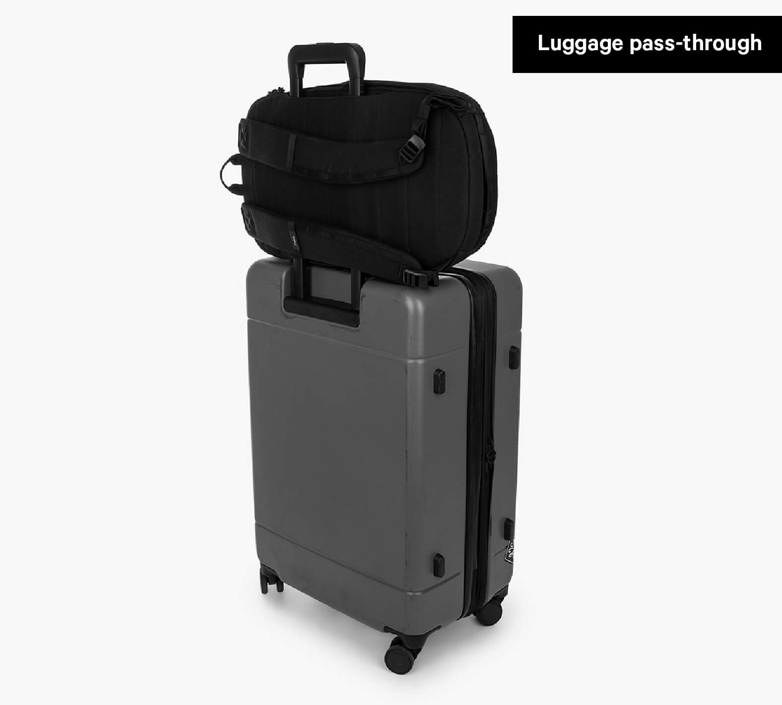 Black Everyday 22L backpack attached to upright suitcase via Luggage pass-through strap