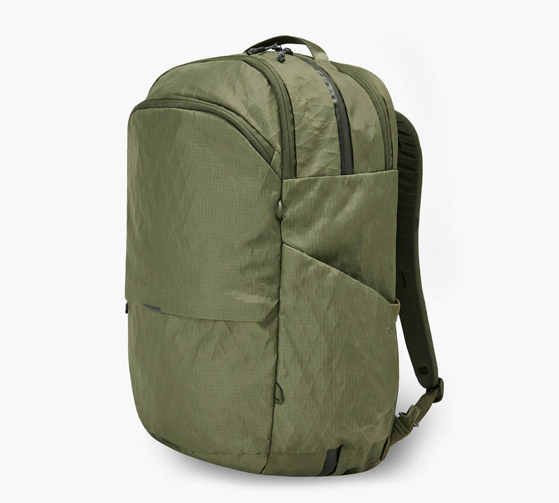 Olive green daypack with top zipper, front and side pockets, and padded shoulder straps.