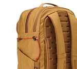 Tan backpack showing padded ventilated back panel, shoulder straps, and side pocket with red bungee cord