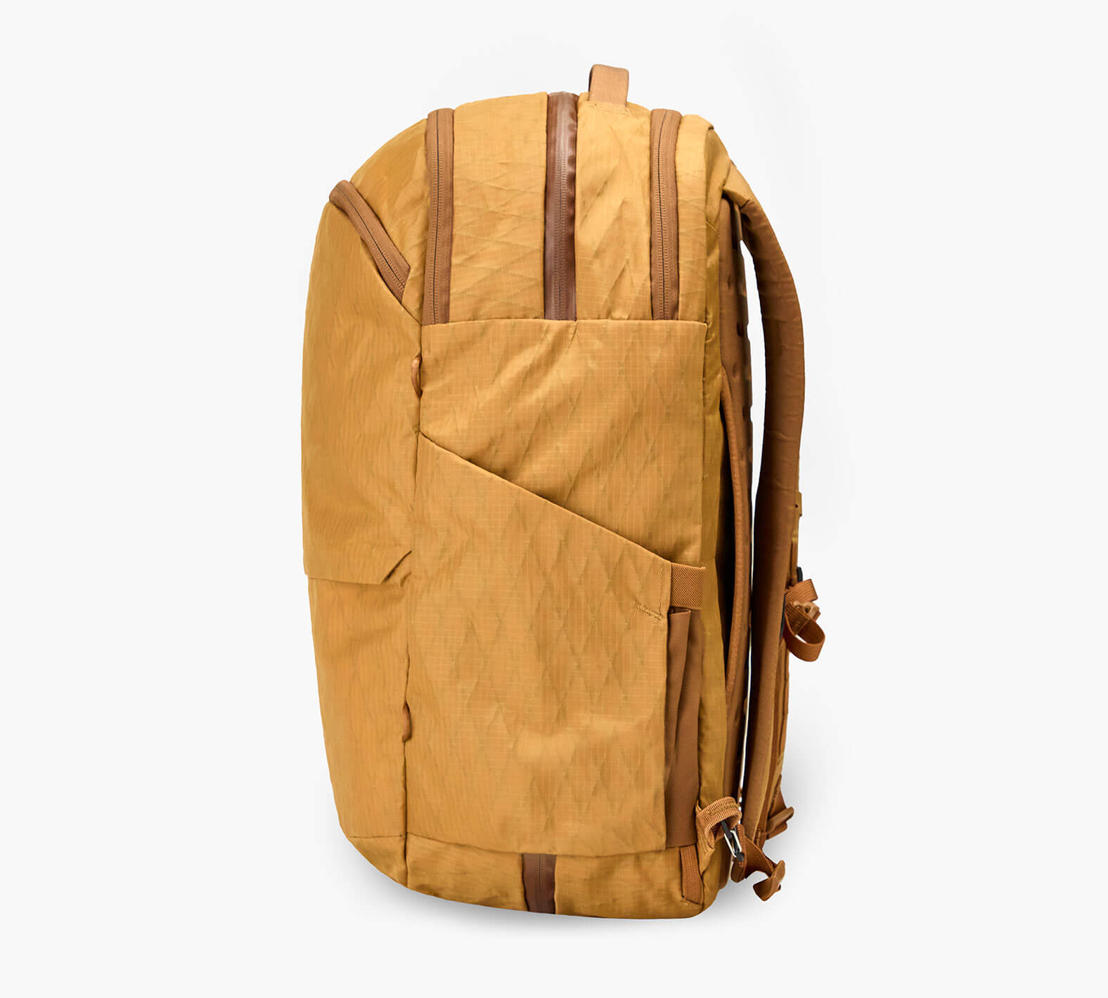 Side view of Cero Travel Backpack in Mojave showing external side pocket, brown vertical zipper accents, and padded shoulder straps