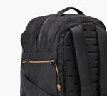 Black backpack with padded molded back panel, zippered front pocket, top carry handle, and shoulder straps.