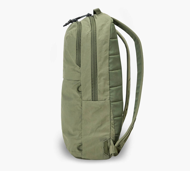 Olive green slim daypack, side profile showing vertical zip pocket, top zipper and padded shoulder straps.