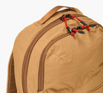 Tan Stash packable backpack with two zip compartments and red corded zipper pulls
