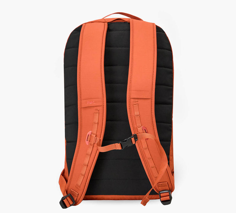 Back view of an orange Stash packable backpack showing padded shoulder straps, sternum strap, and quilted back panel.