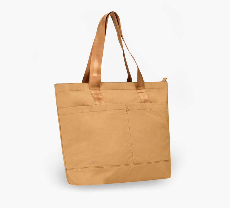 Tan canvas tote bag with front pockets and long shoulder straps