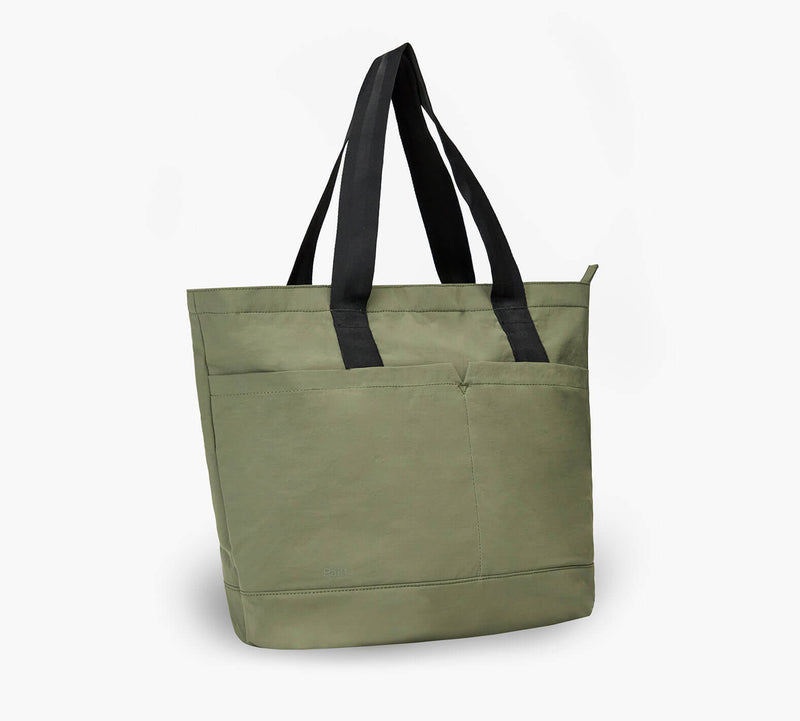 Olive green canvas tote bag with black shoulder straps and front exterior pocket.