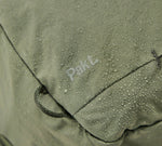 Close-up of water-resistant fabric with water droplets and the word 'PakL' visible