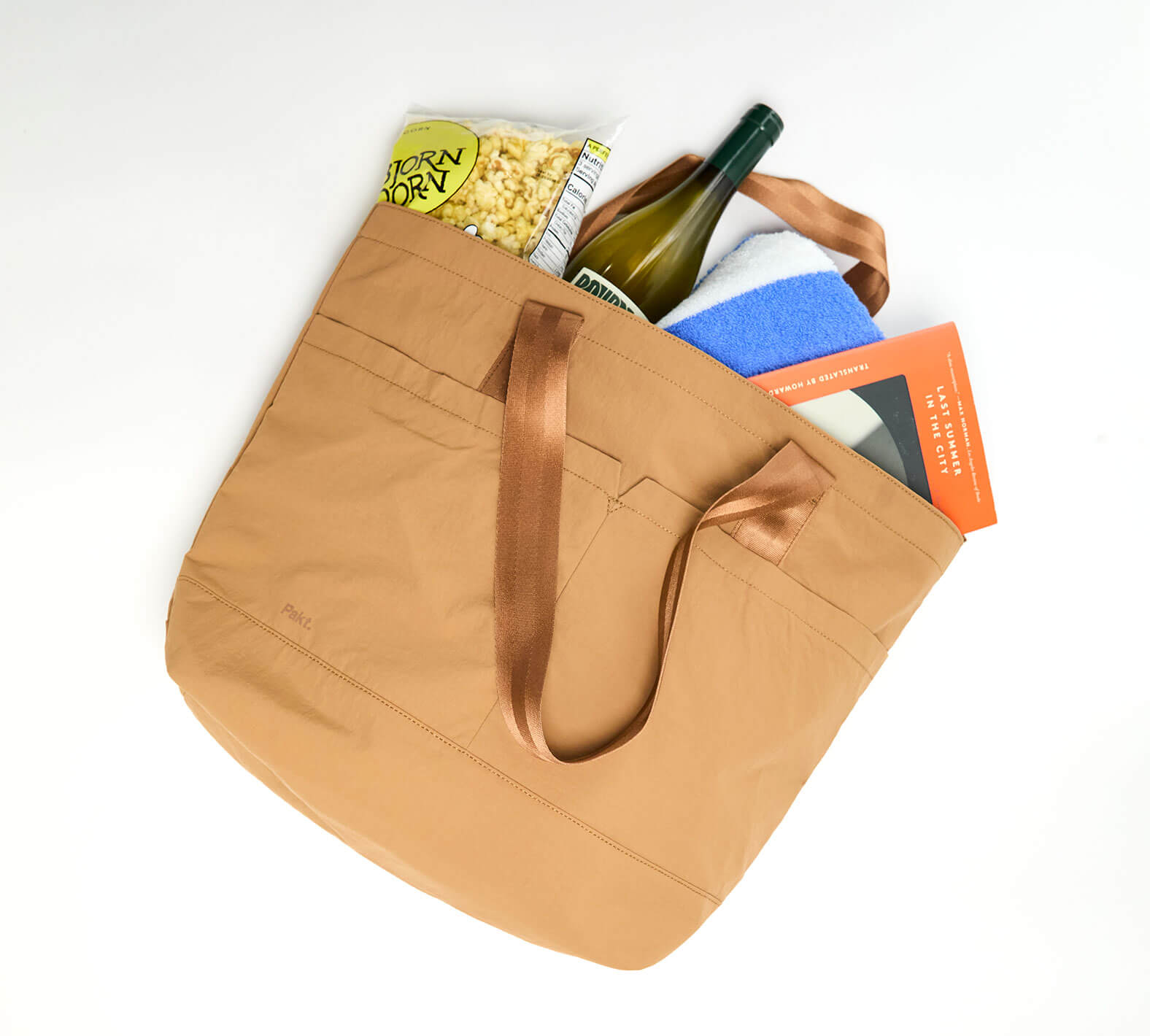 Top-down view of Stash Packable Tote 20L, Mojave, showing roomy interior, exterior pocket, and double handles on white background
