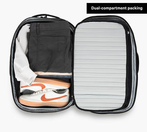 Travel Backpack Grey storage space demonstrated holding tennis shoes