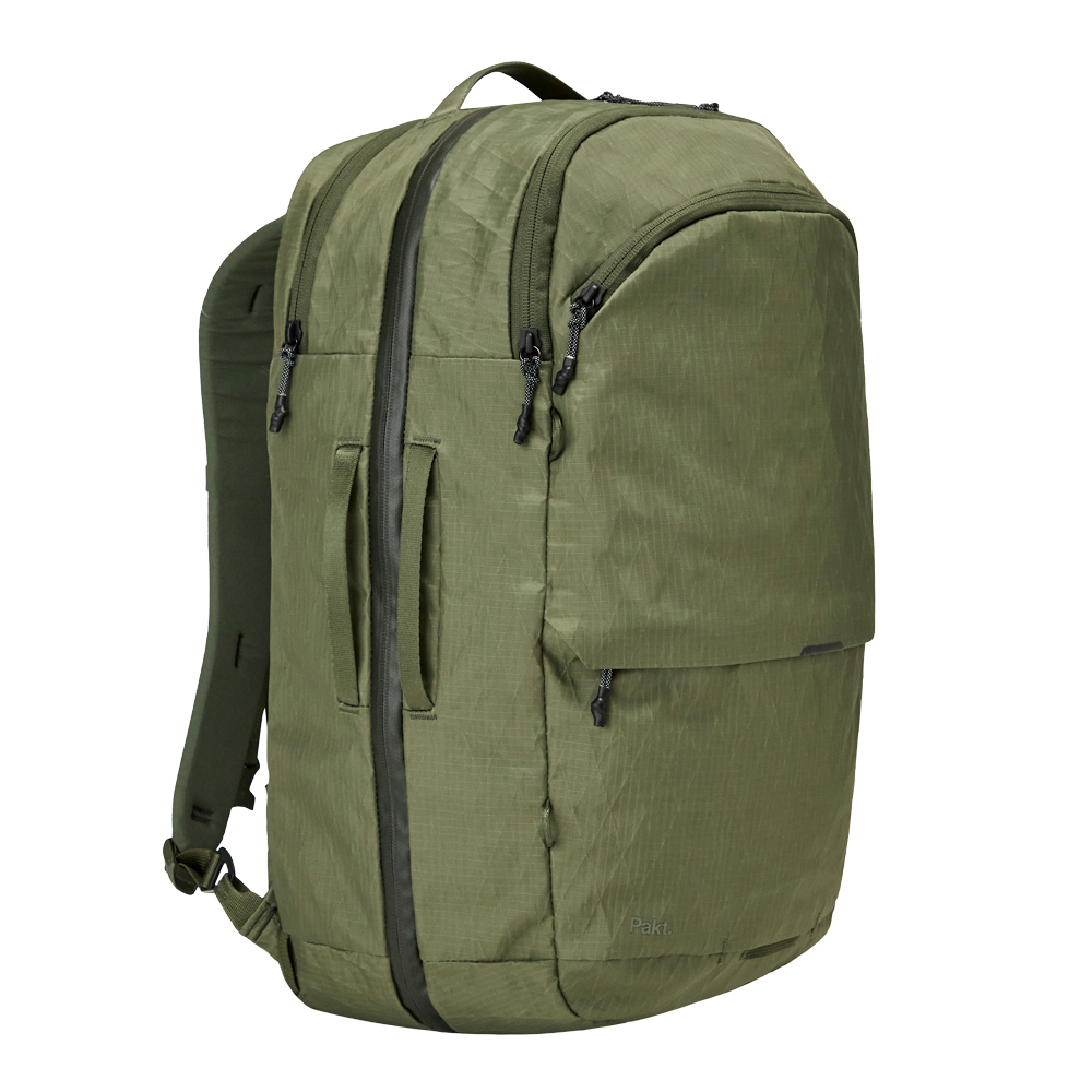 Olive-green travel backpack with dual front zippers, side carry handles and 'Pakt.' logo.