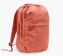 Coral canvas daypack backpack with front zip pocket and padded shoulder straps.