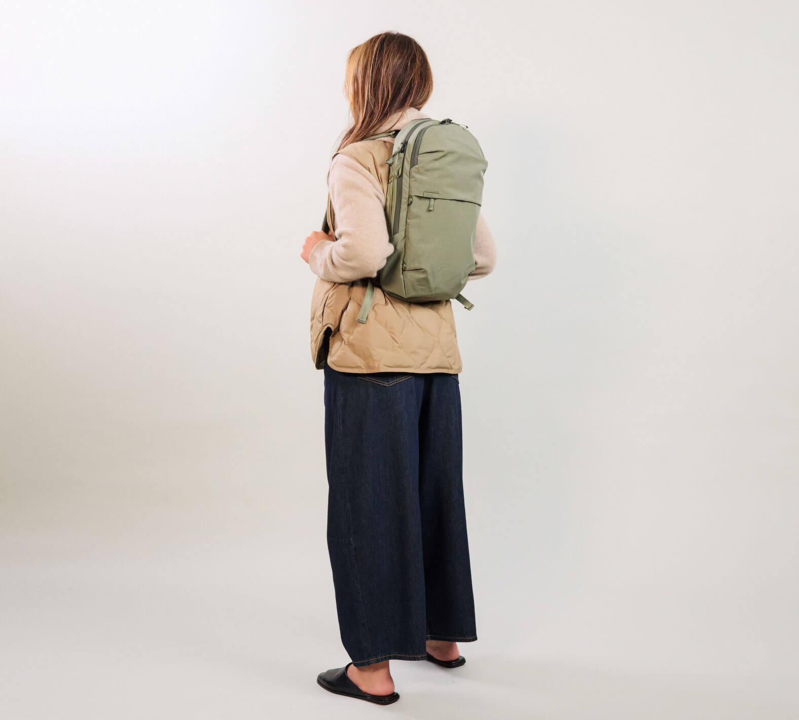 Back view of MODE Convertible Bag 14L in Cypress worn as a backpack showing padded detachable shoulder straps on neutral background