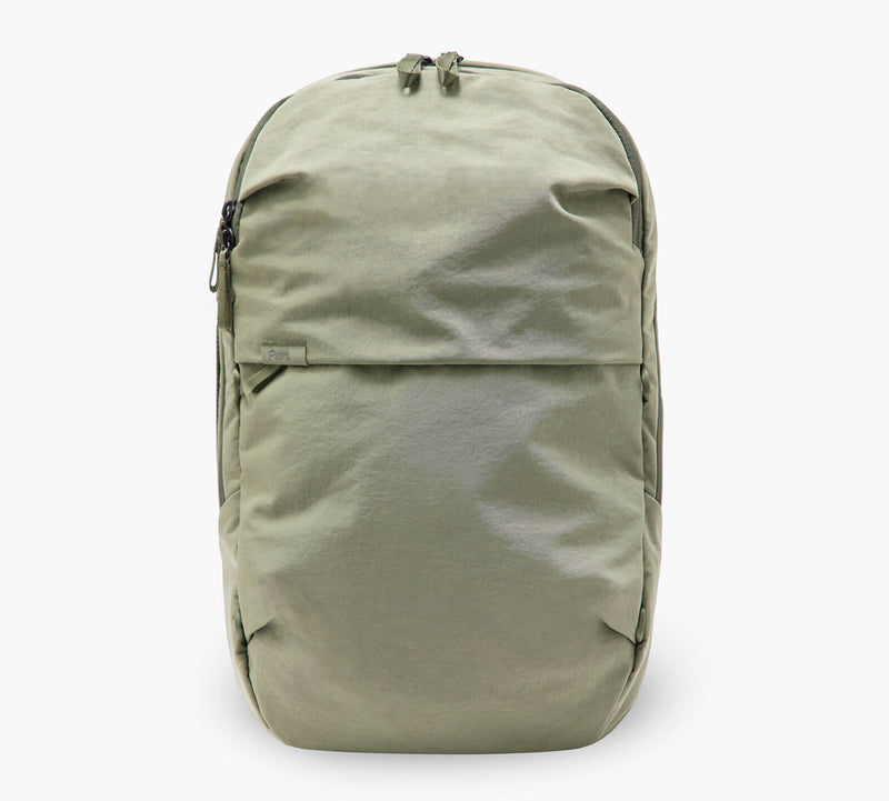 Olive-green minimalist backpack with top zipper and large front zippered pocket