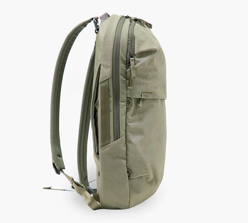 Olive-green backpack, side profile with padded shoulder straps, side zip pocket and top zipper