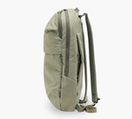 Olive-green backpack, side view showing zippered side pocket, water bottle sleeve, and padded shoulder straps.