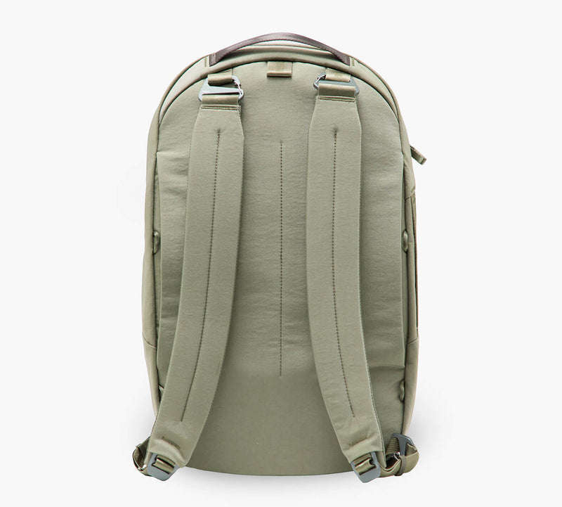 Sage green backpack, rear view — padded shoulder straps, top carry handle, and side zipper pocket.