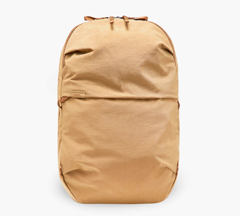 Tan canvas backpack with front zip pocket and top carry handle
