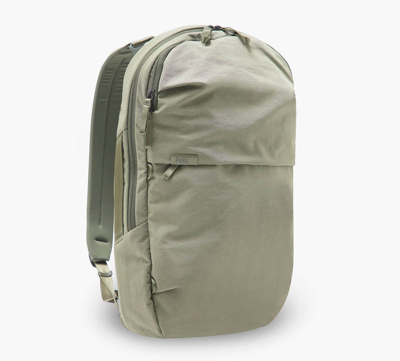 sage-green travel backpack with front zip pocket, padded back panel, and side water-bottle pocket
