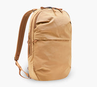 Three-quarter view of MODE Convertible Bag 14L in Mojave showing front pocket, top zipper, and straps on white background