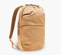 Three-quarter view of MODE Convertible Bag 14L in Mojave showing front pocket, top zipper, and straps on white background