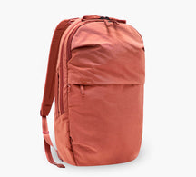 coral backpack with front zip pocket and side water-bottle pocket, three-quarter view