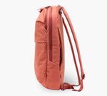 Coral backpack, side profile showing zippered pocket and padded shoulder straps.