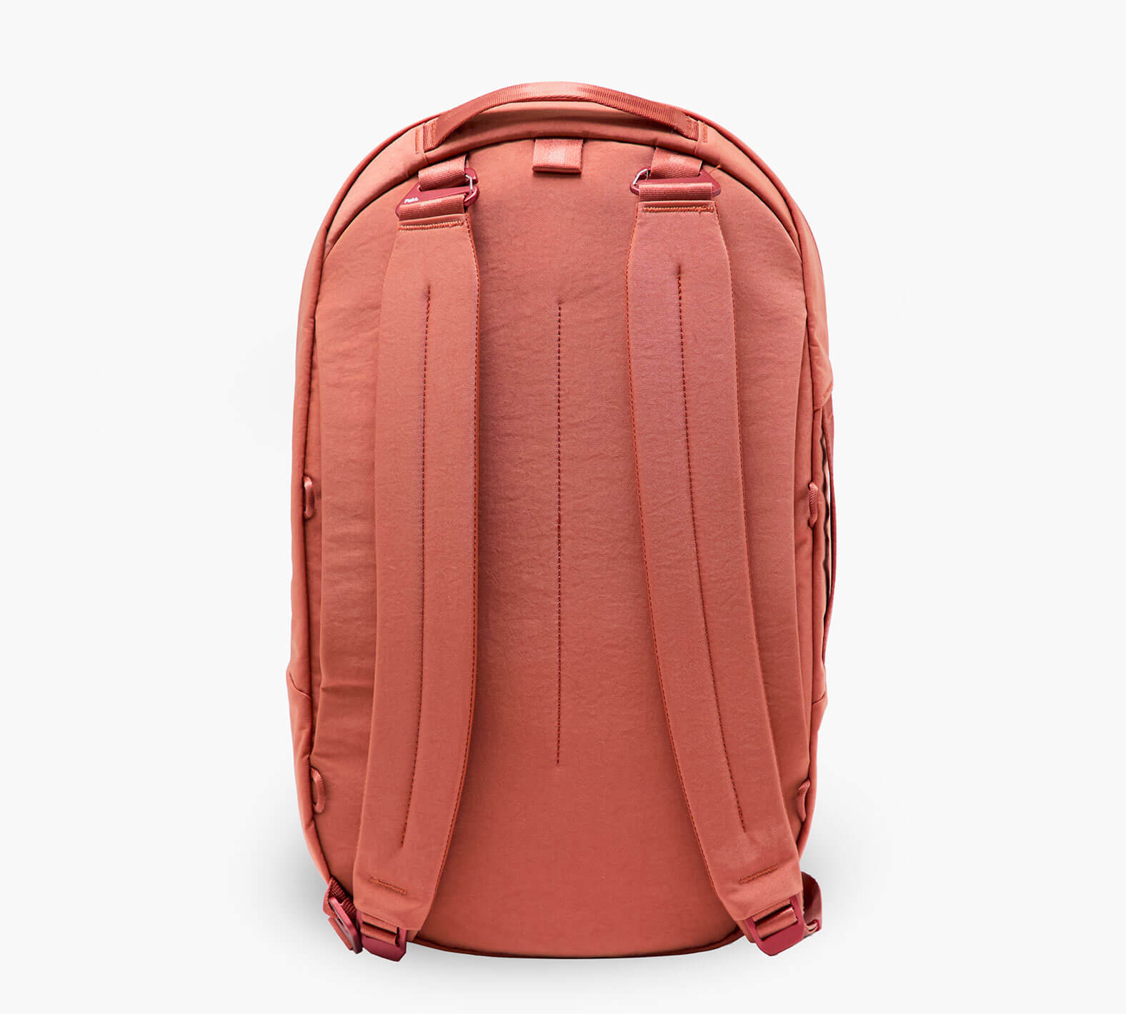 Back view of coral backpack with padded shoulder straps, top carry handle, and rounded zippered body.
