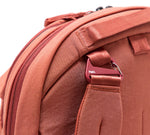 Rose backpack strap and zipper close-up with red carabiner labeled Pakt.