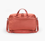 Coral duffel bag with top handles and adjustable shoulder strap, front zip pocket