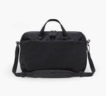 Black rectangular travel weekender bag with top handles, adjustable shoulder strap and front zip pocket.