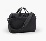 Black padded laptop travel bag with top handles, adjustable shoulder strap, and front zip pocket