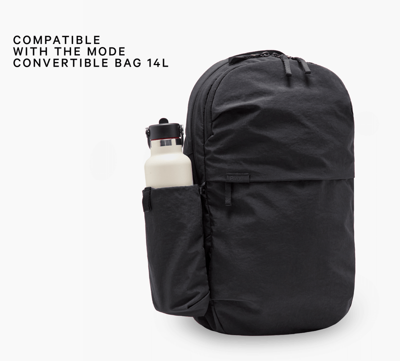 COMPATIBLE WITH THE MODE CONVERTIBLE BAG 14L — black backpack showing side bottle sleeve holding white bottle
