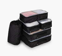 Stack of five black packing cubes with translucent mesh tops and one black drawstring pouch