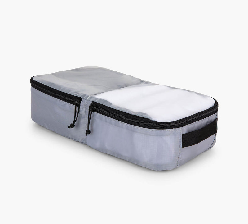 Light gray rectangular packing cube with dual black zippers and side handle