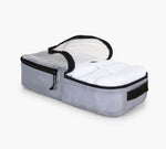 Gray rectangular packing cube with open lid showing folded white bedding inside