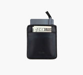 Slim black leather card pocket holding a gray card and a folded bill showing "20" in front.