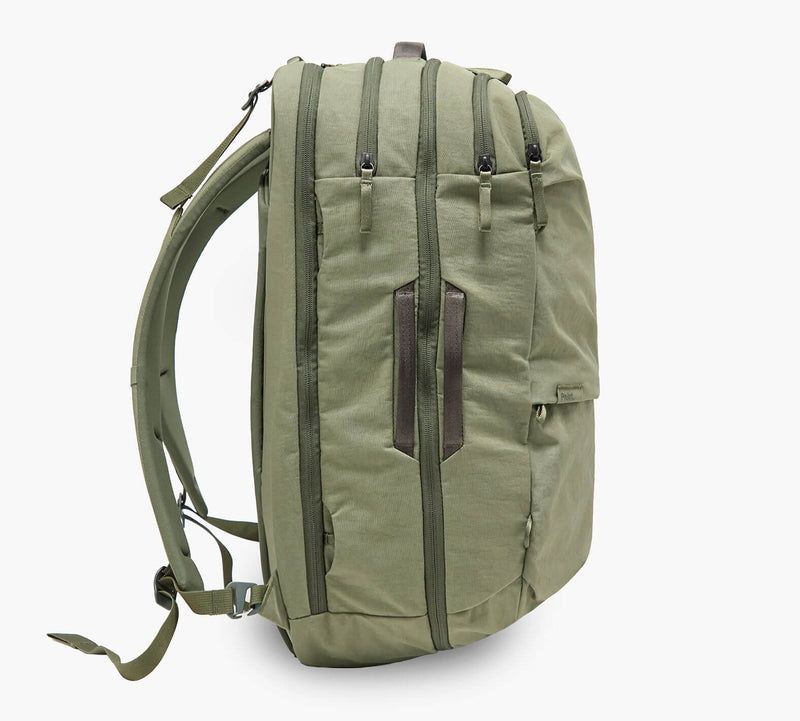 Olive-green travel backpack, side view showing zippered compartments and padded shoulder straps