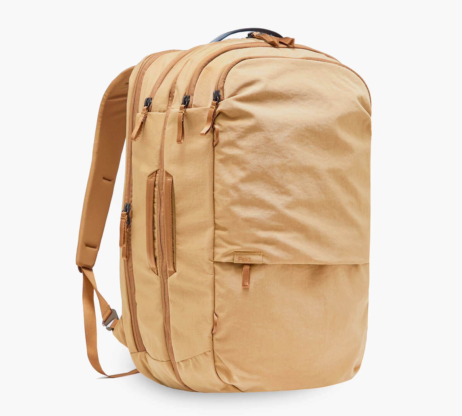 Three-quarter view of Pakt One Travel Backpack in Mojave with three zippered compartments, expandable front pocket, padded shoulder straps