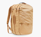 Tan canvas travel backpack with two zippered compartments, padded shoulder straps and top handle.