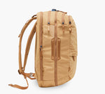 Tan backpack, side view with padded shoulder straps, two vertical zippered pockets and leather-look strap detail.