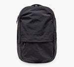 Black everyday backpack with front zip pocket and top carry handle.