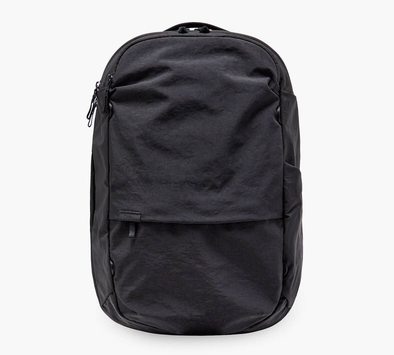 Black everyday backpack with front zip pocket and top carry handle.