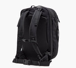 Black travel backpack, back view with padded shoulder straps, adjustable sternum strap and padded hip belt.