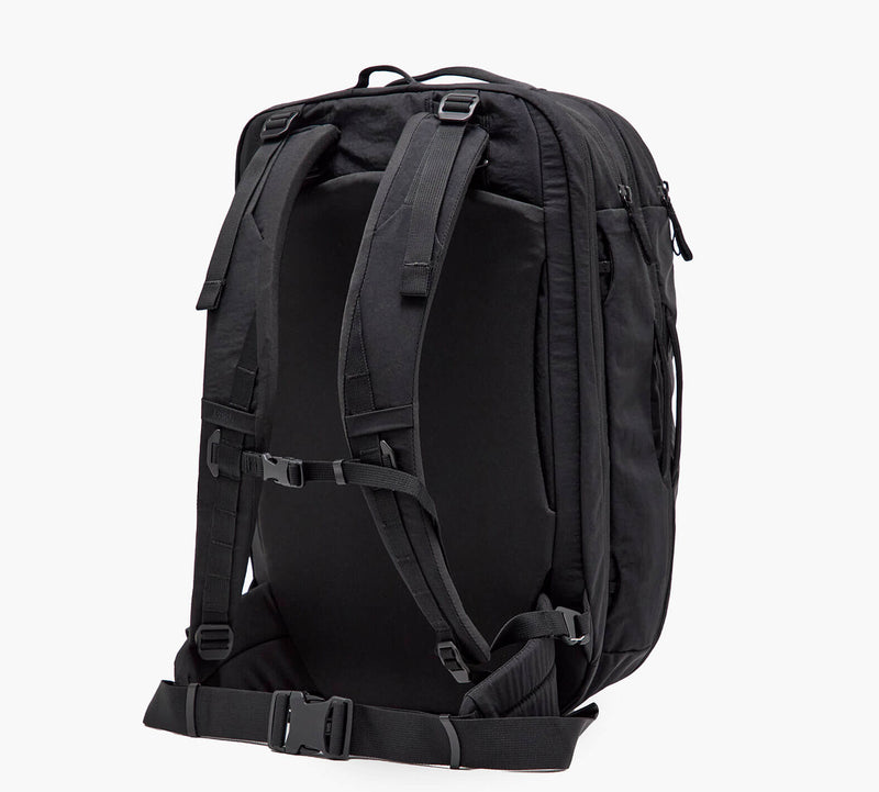 Black travel backpack, back view with padded shoulder straps, adjustable sternum strap and padded hip belt.