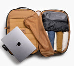 Open carry-on suitcase with a laptop being removed and neatly packed clothes inside