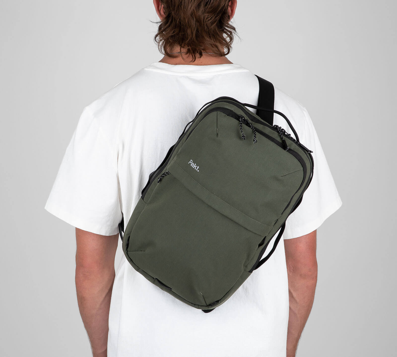 Man with green sling backpack