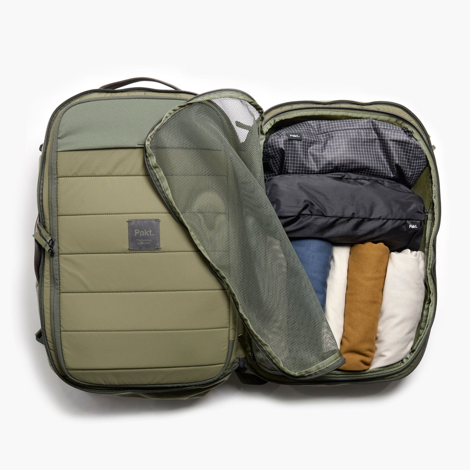 Overhead view of Pakt One Travel Backpack interior showing mesh divider and packing cubes in cypress on white background