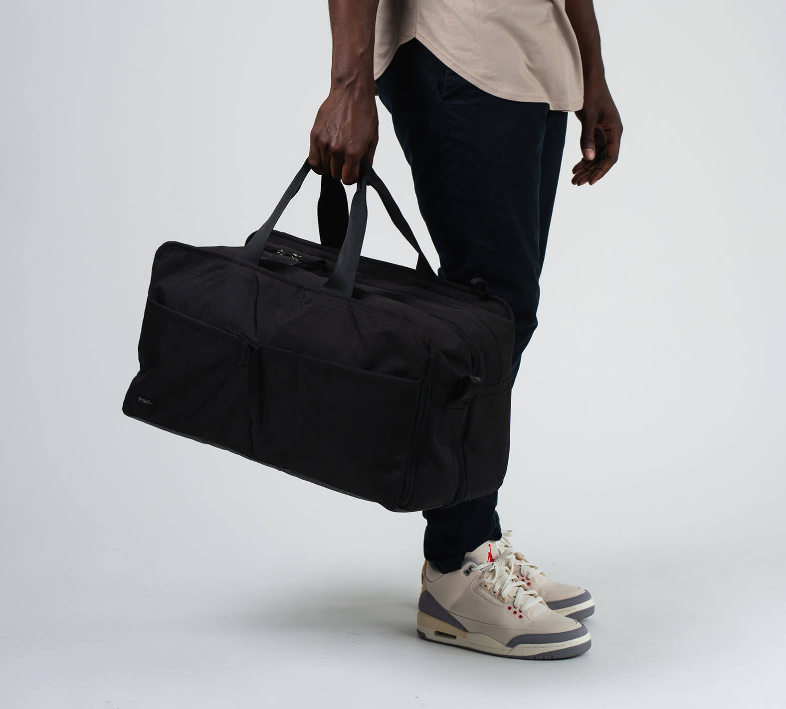 the 50L duffel/backpack in black has extra long handles for carrying by hand or over the shoulder