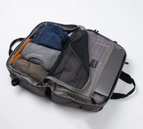 the pakt one duffel packed with clothing and a laptop